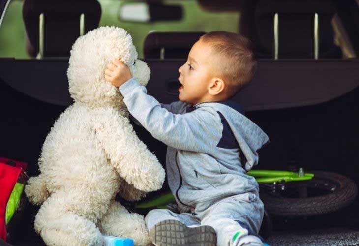 Toddler playing with cuddly sheep toy