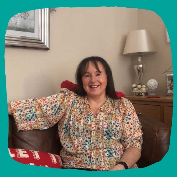 Foster carer sitting on sofa next to Christmas tree