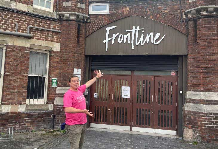 Foster carer Phil pointing at Front Line building