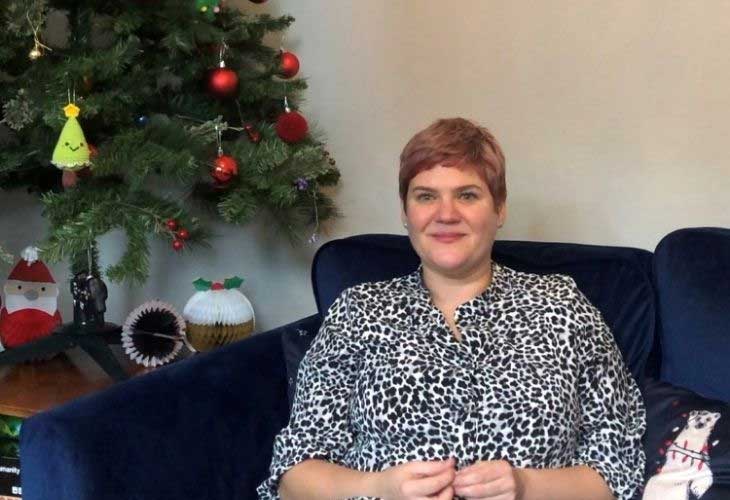 Foster carer sat on sofa next to christmas tree